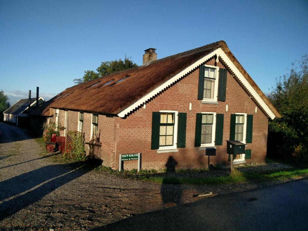 een oud rood bakstenen huis met een bruin dak bij Klein Kokanje in Kockengen