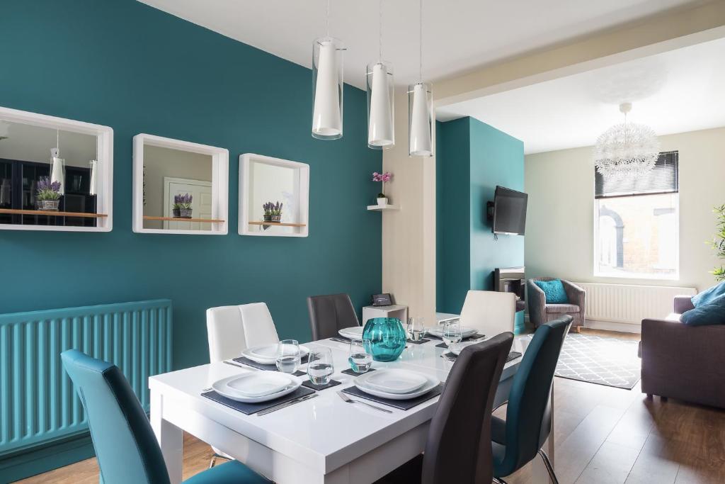 uma sala de jantar com uma mesa branca e paredes azuis em Bishop's Rest em Bishop Auckland