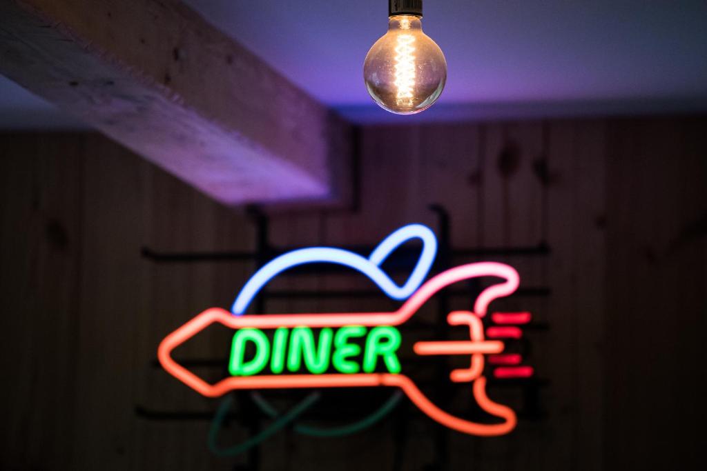 a neon dinner sign in a room with a light at Tangs in Ísafjörður