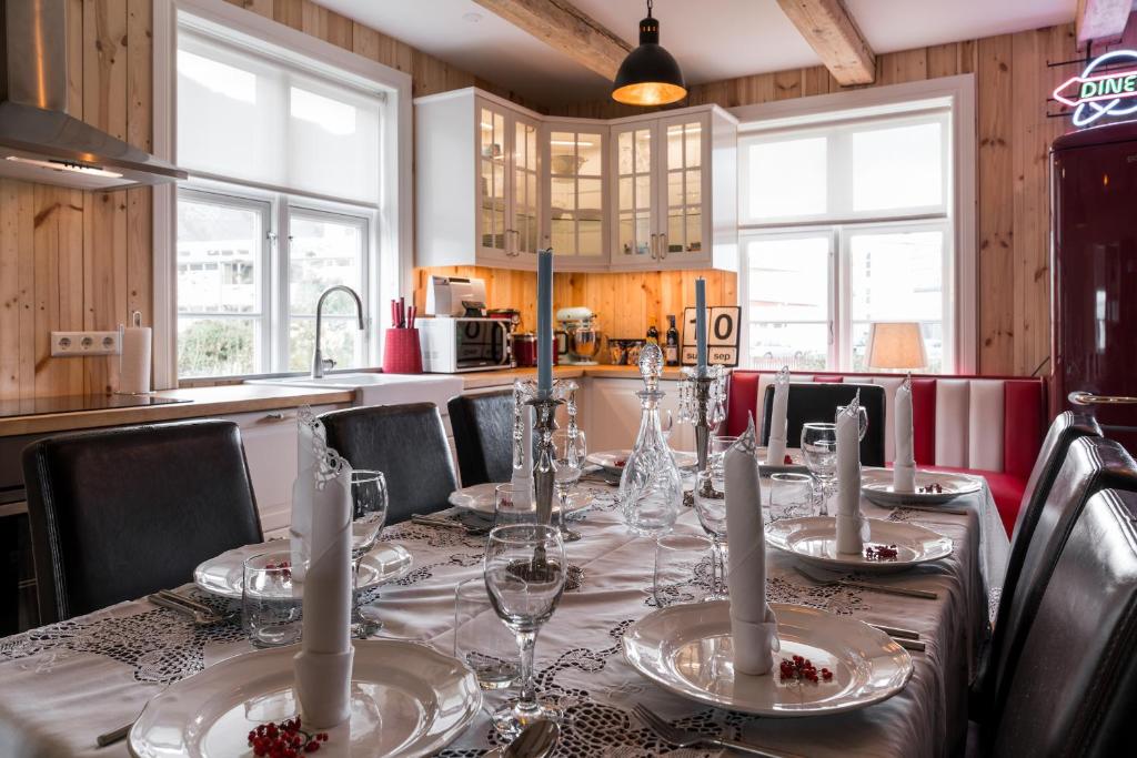 a dining room table with plates and glasses on it at Tangs in Ísafjörður