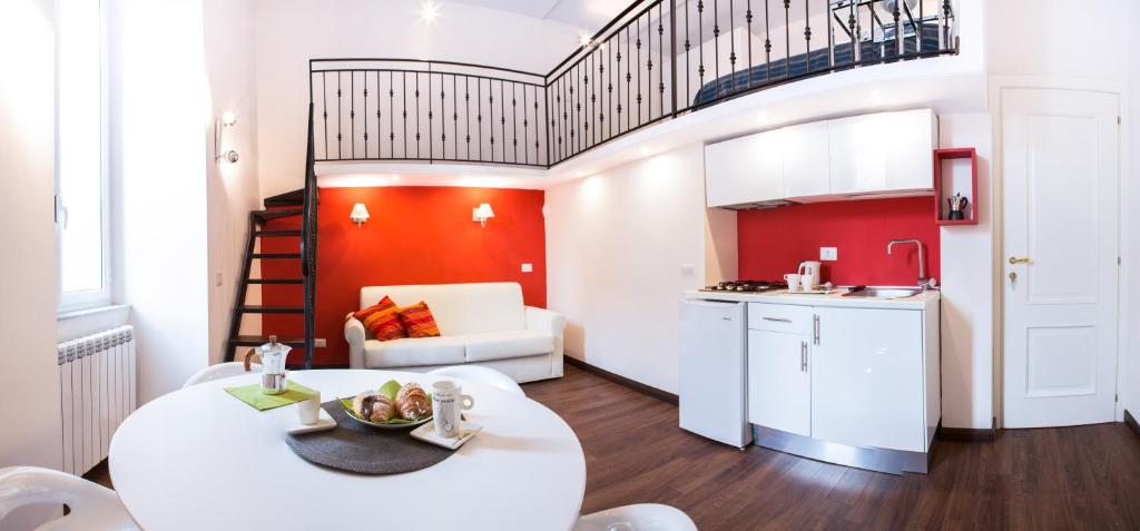 a living room with a white table and a kitchen at Appartamenti Mergellina in Naples