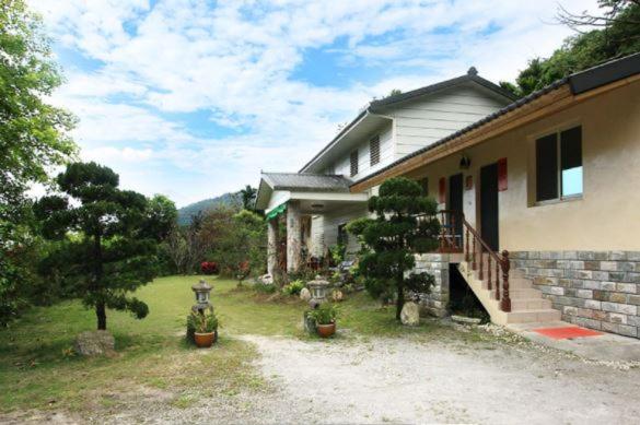 una casa con piante in vaso davanti di Sand Po Dang B&B a Xiulin