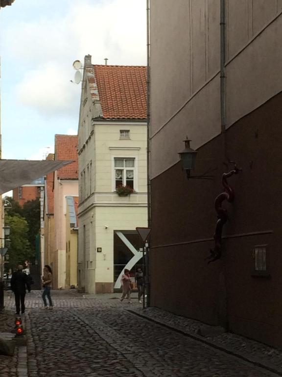 a cobblestone street in a city with a building at Studio Apartment Old Town in Klaipėda