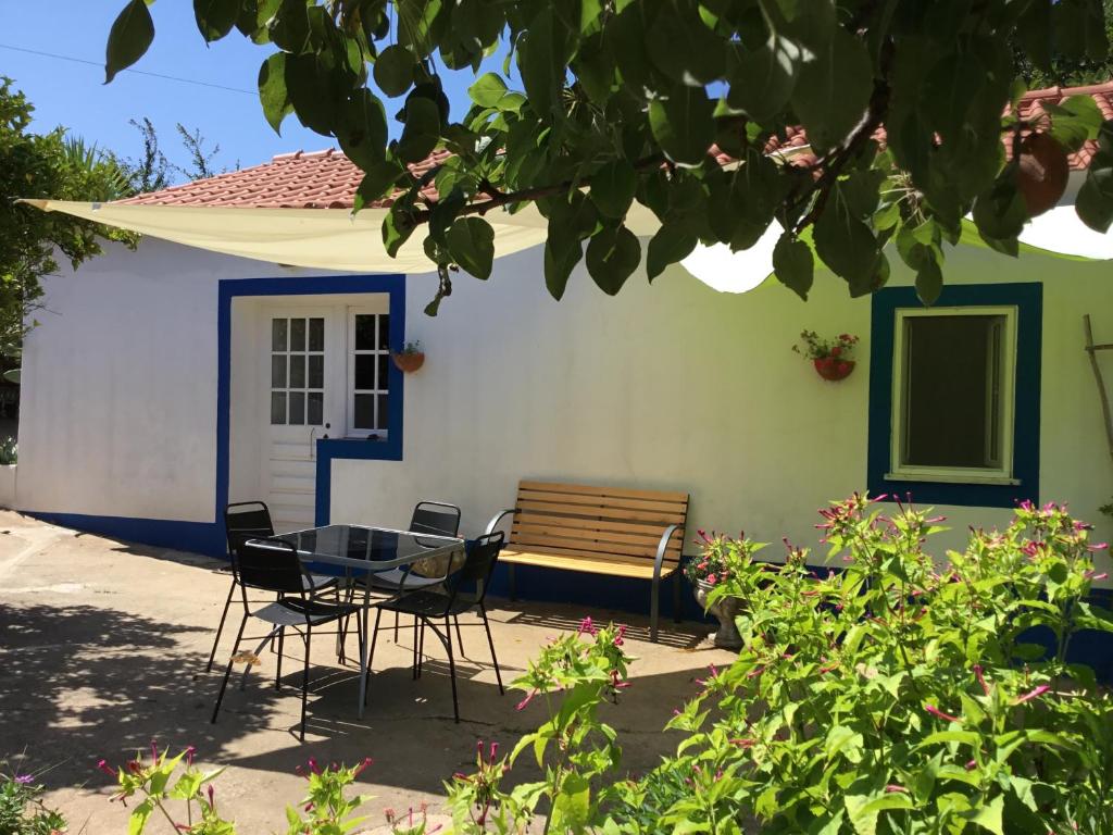 a table and chairs in front of a house at Quinta Boavista in Cercal
