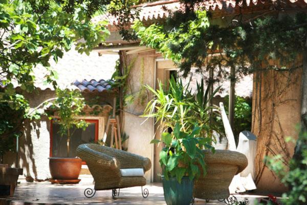 un patio con sillas y macetas y un edificio en Mas de L'Ermitage, en Lattes