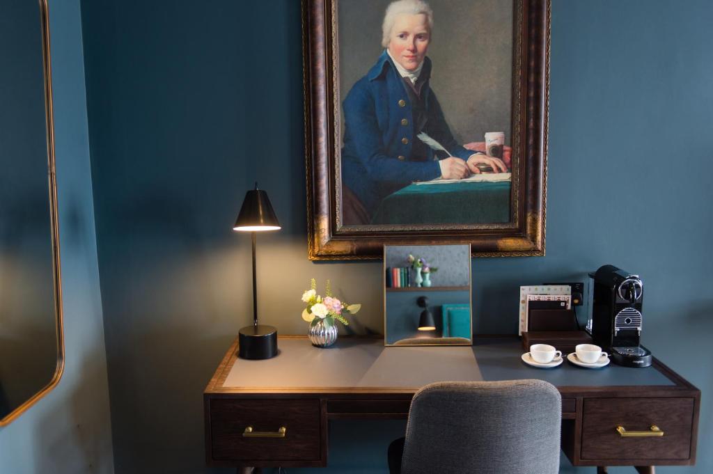 a room with a desk with a painting of a woman at Avon Gorge by Hotel du Vin in Bristol