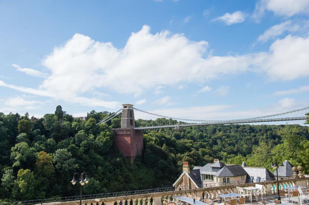 a suspension bridge in the middle of a town with houses at Avon Gorge by Hotel du Vin in Bristol