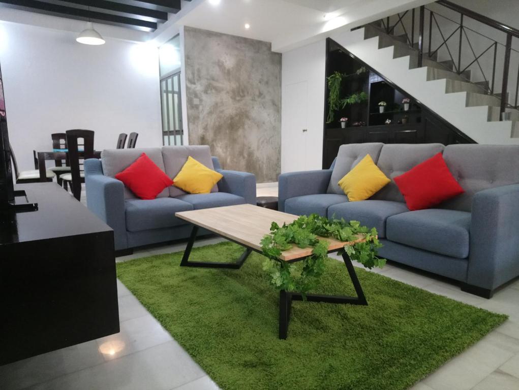 a living room with two couches and a table at Escape to Bukit Indah Legoland Retreat Your 5BR Homestay for 1-16 Guests in Johor Bahru