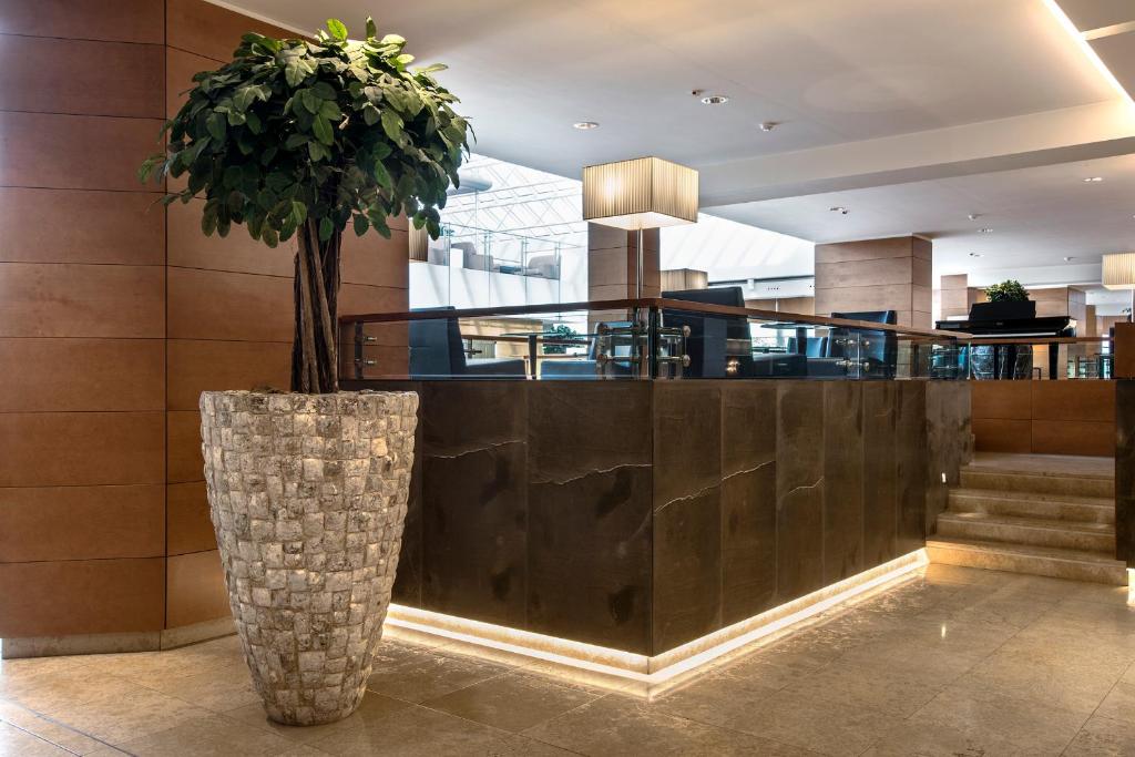 hol z rośliną w dużym wazonie w obiekcie Ergife Palace Hotel w Rzymie