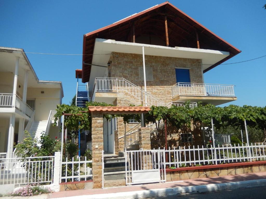 uma casa com uma cerca branca em frente em Noula Rooms em Makrýgialos