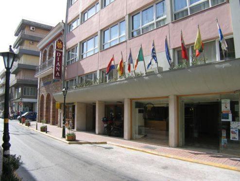 un edificio con banderas al lado de una calle en Diana Hotel en Chios