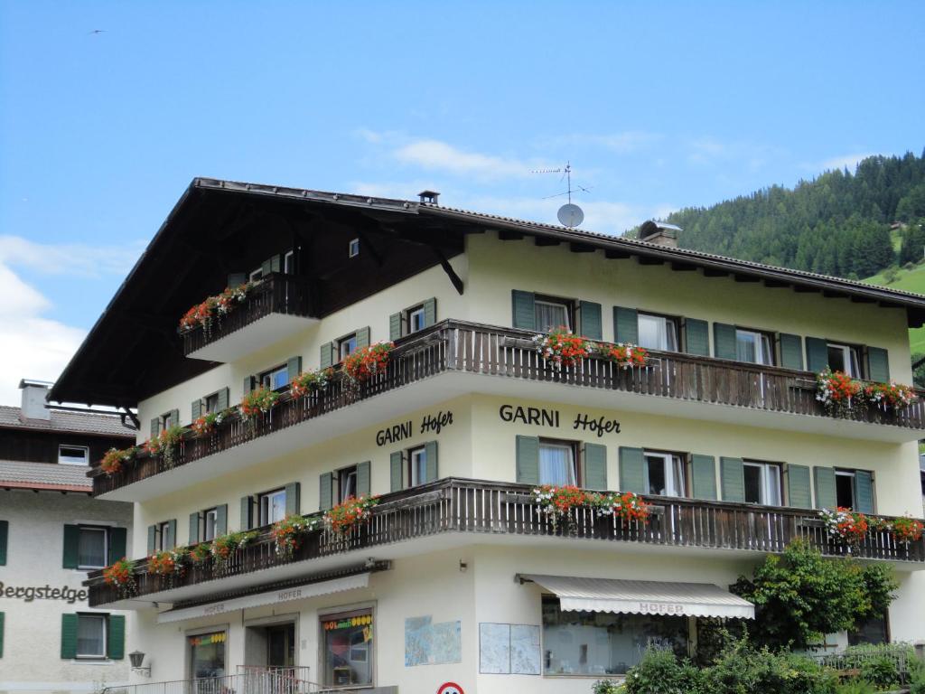 un edificio con balconi e fiori di Garni Hofer a Sesto