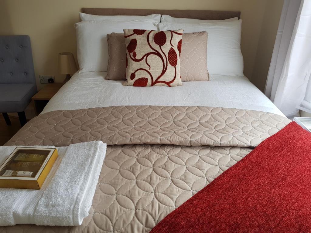 a bedroom with a bed with a red rug at Kathleen House Plus in Enfield