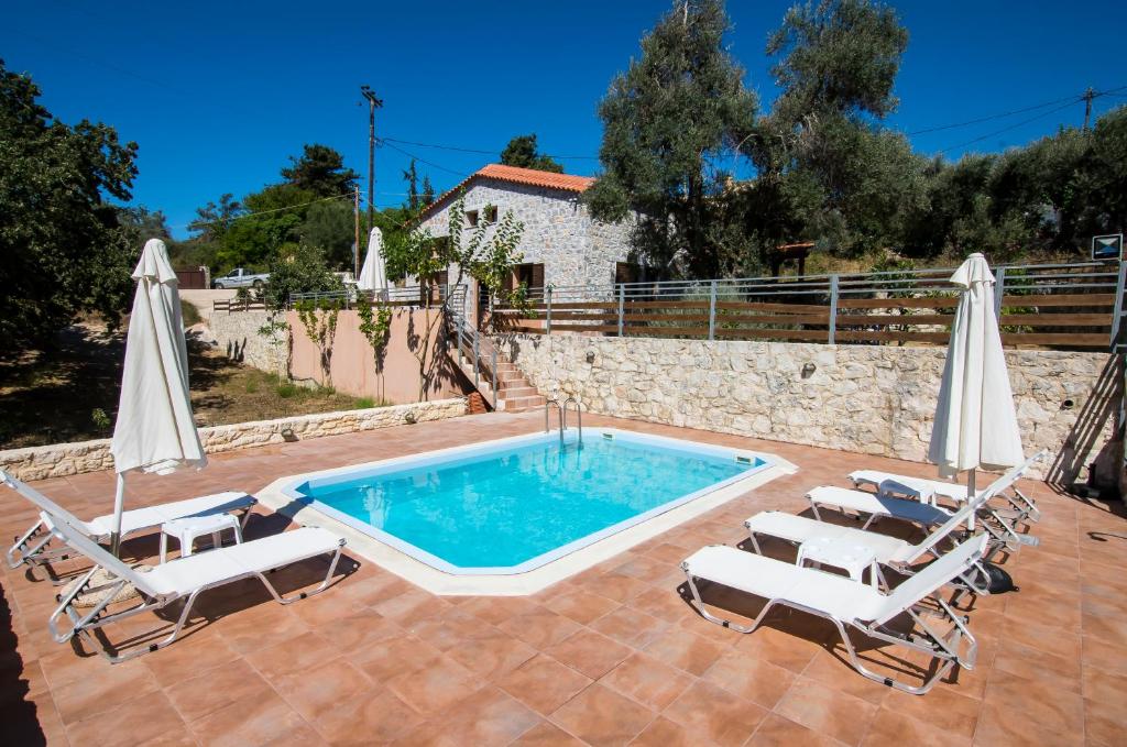 einen Pool mit zwei Stühlen und einem Pool in der Unterkunft Horizon Villa Kastellos Rethymno in Kástellos