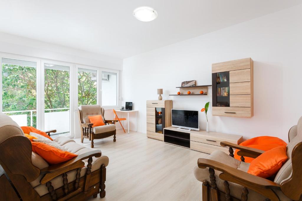 een woonkamer met oranje kussens en een woonkamer bij Botun Apartman free parking in Pula