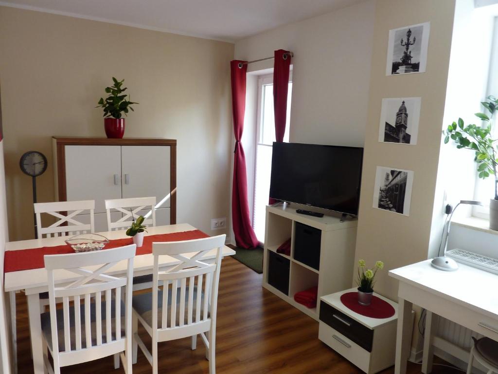 a living room with a table and a television at City Apartment Jena in Jena