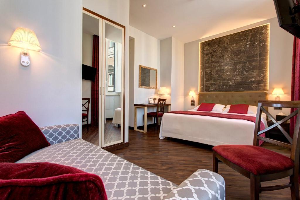 una camera d'albergo con due letti e uno specchio di Hotel Nazionale a Roma