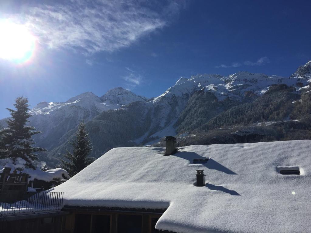 a snow covered roof with mountains in the background at Le petit Saint Bernard in Sainte-Foy-Tarentaise