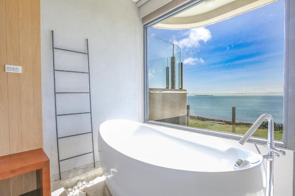 a bath tub in a bathroom with a large window at Laguna Villas & Resorts in Magong