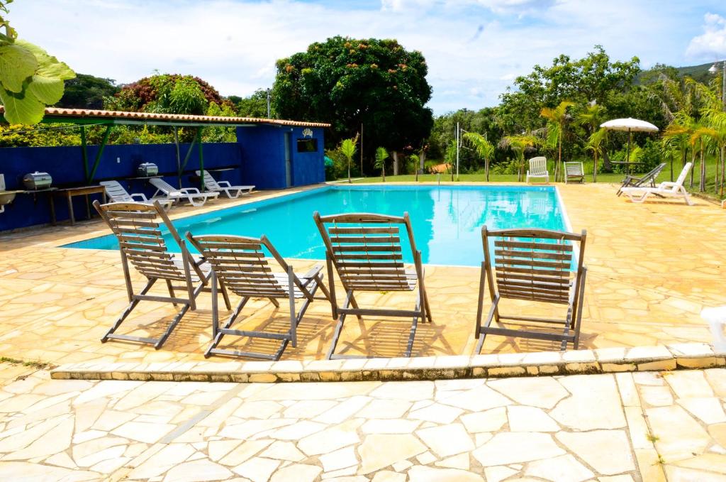 a group of chairs sitting next to a swimming pool at Pousada Recanto Do Sossego in Serra do Cipo