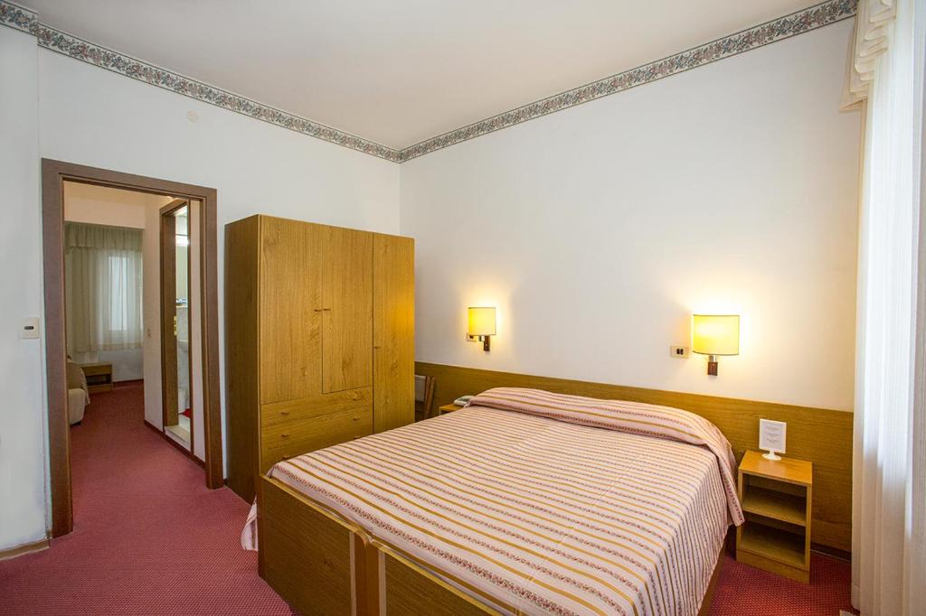 Säng eller sängar i ett rum på Hotel Lido