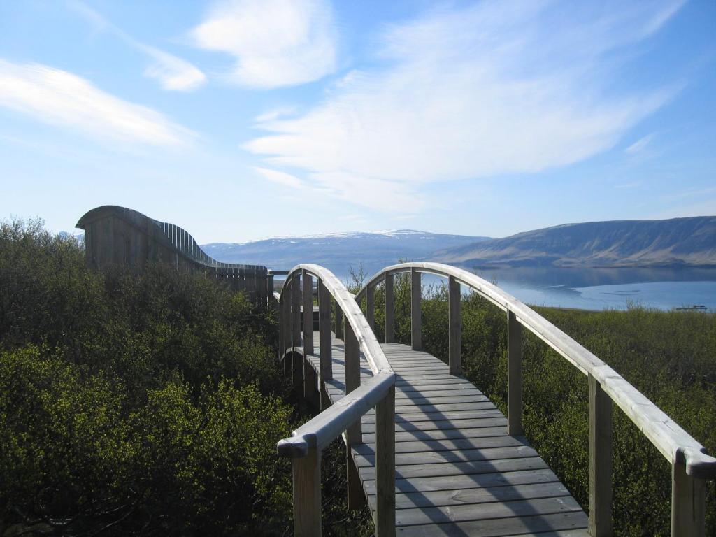 a wooden walkway with a view of a lake at Hotel Glymur in Leirá