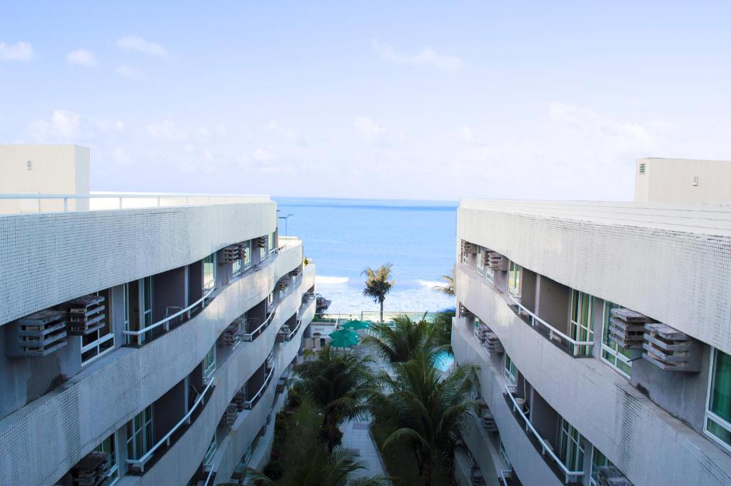 una vista del océano desde dos edificios en Apartamentos Deluxe Ponta Negra Beach, en Natal