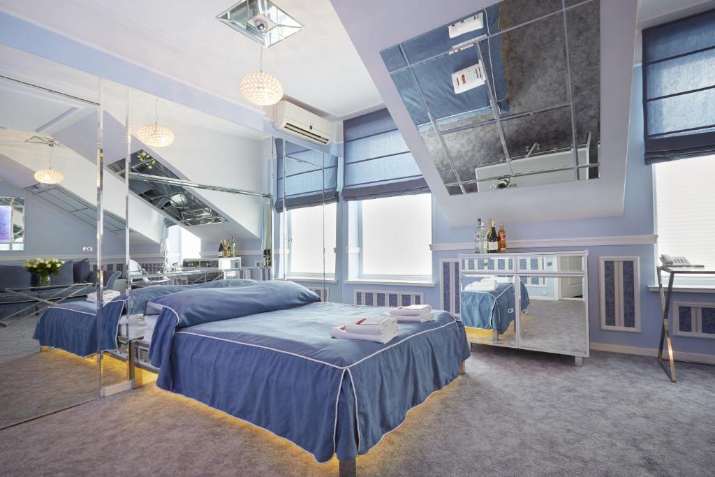 a bedroom with two beds with blue sheets at Hotel Senator Konferencje & SPA in Starachowice