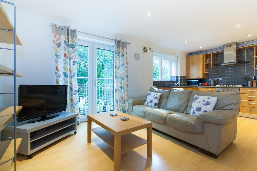 a living room with a couch and a tv at Rest & Recharge - Birley View in Manchester