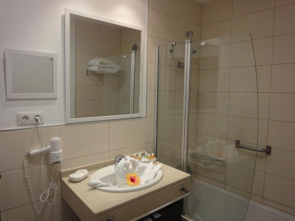 a bathroom with a sink and a glass shower at Balneario Pozo de la Salud in Sabinosa