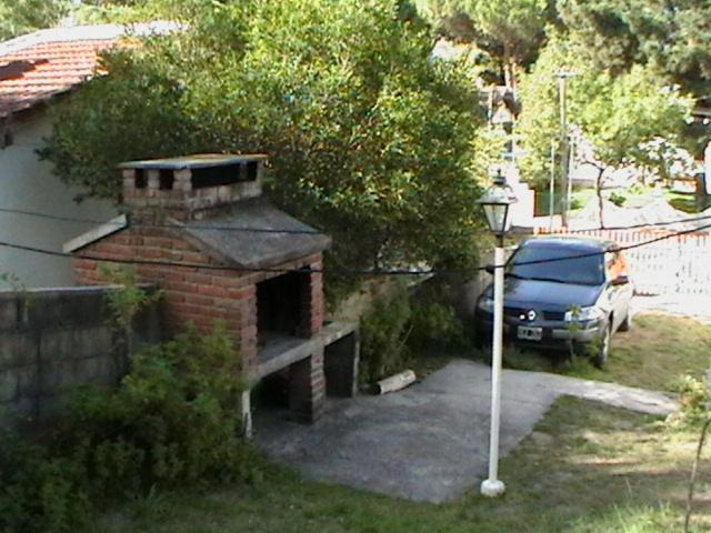 un horno de ladrillo con un coche aparcado en la entrada en Comodo Chalet en Gesell en Villa Gesell