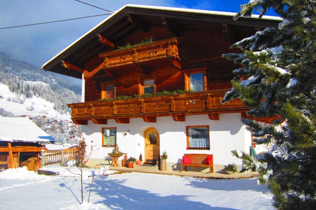 una cabaña de madera en invierno con nieve en el suelo en Ferienhaus Manuela, en Neustift im Stubaital