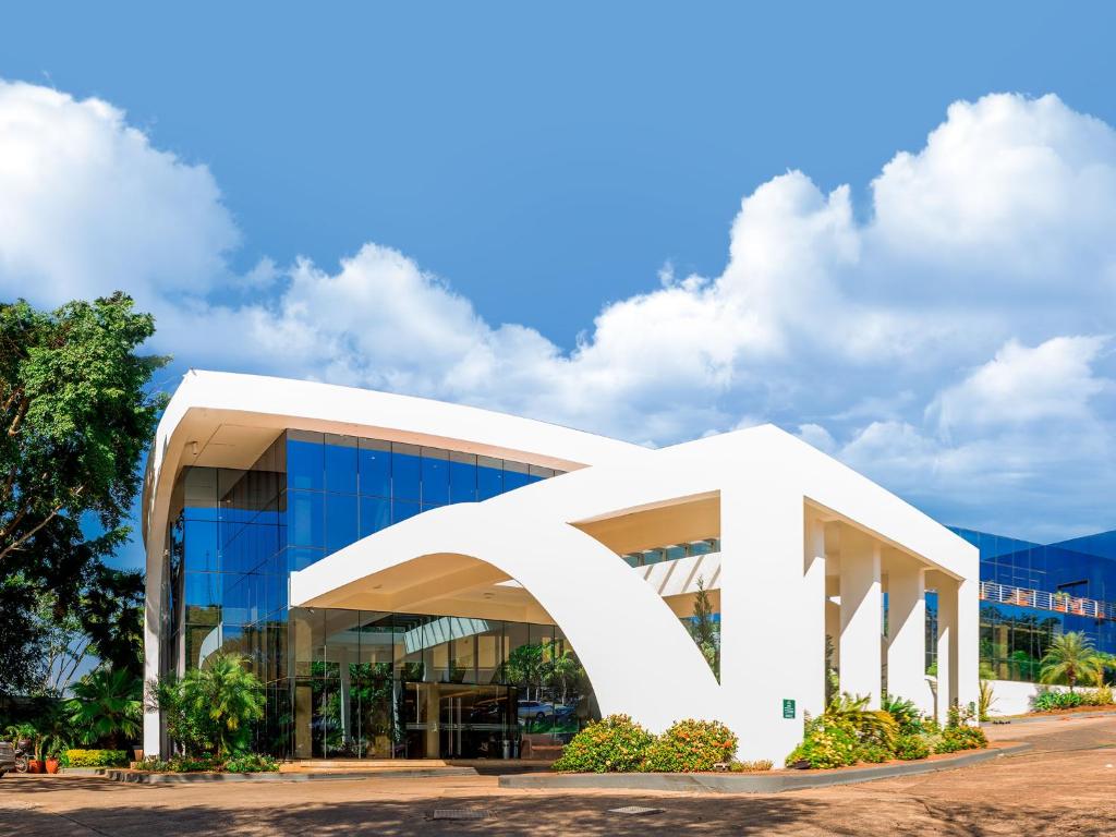 un grand bâtiment blanc avec un fond de ciel ouvert dans l'établissement Hotel Casino Acaray, à Ciudad del Este