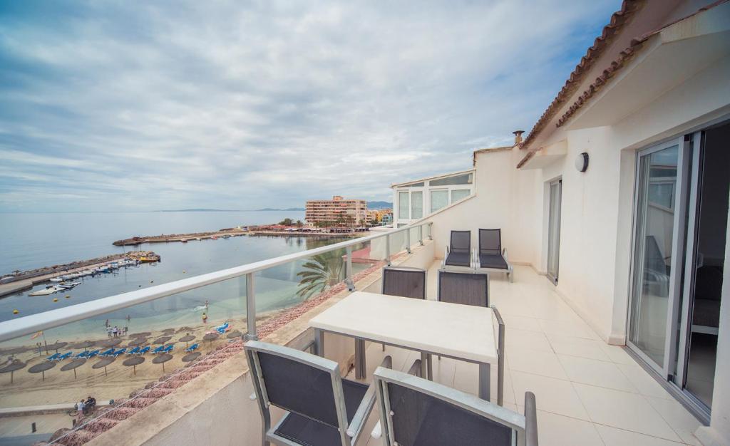 Un balcón con sillas y vistas al océano. en Apartamentos Embat, en Can Pastilla