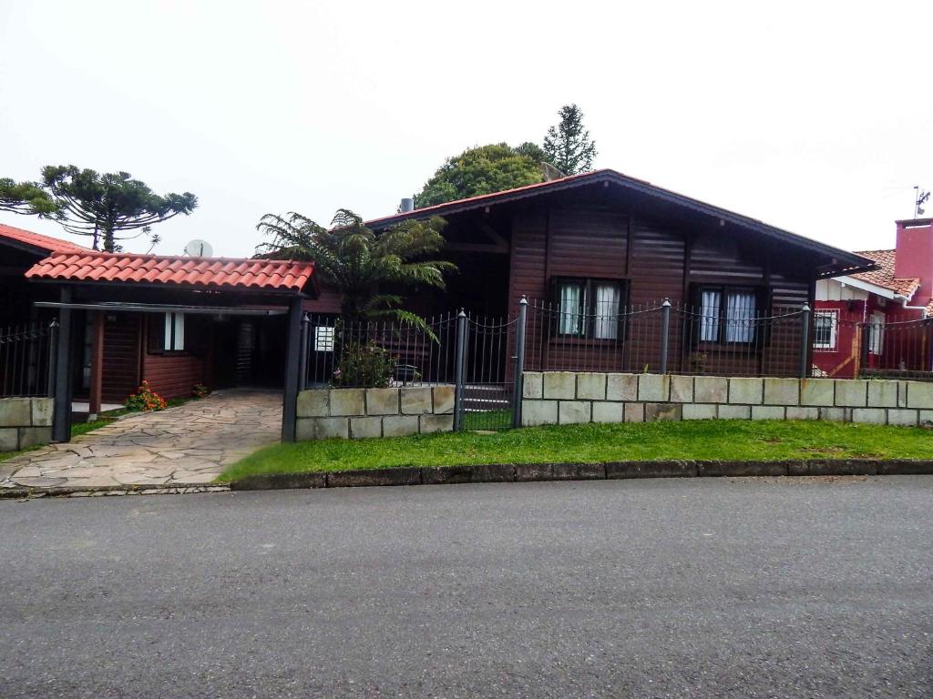 una casa con una valla delante de ella en Chale Bosque da Serra, en Canela