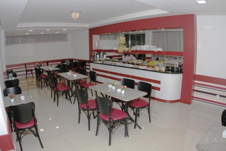 a restaurant with tables and chairs and a counter at Hotel Turella in União da Vitória