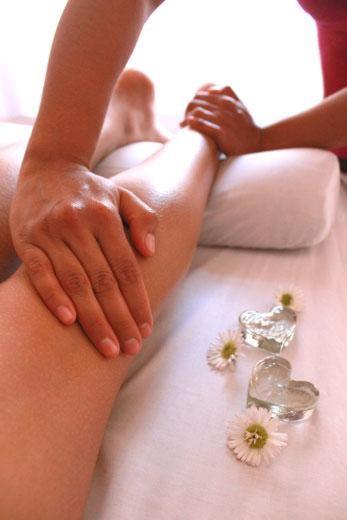 a woman sitting on a bed with her hands on her leg at Balneario Pozo de la Salud in Sabinosa