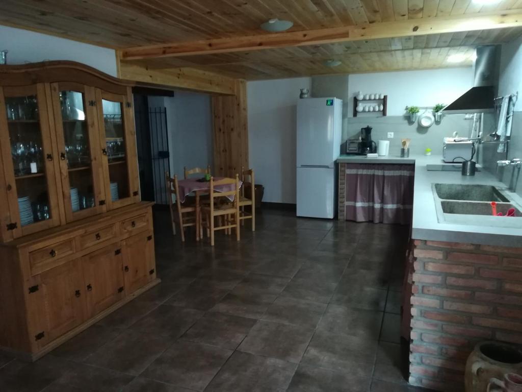 a kitchen with a white refrigerator and a table at La Herreria de Esteban in Cuevas Labradas