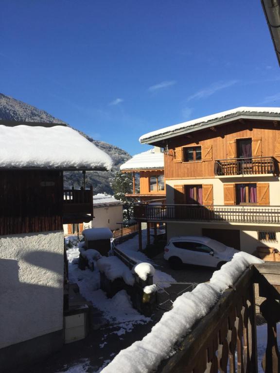 a snow covered house with a car in front of it at Le petit Saint Bernard in Sainte-Foy-Tarentaise