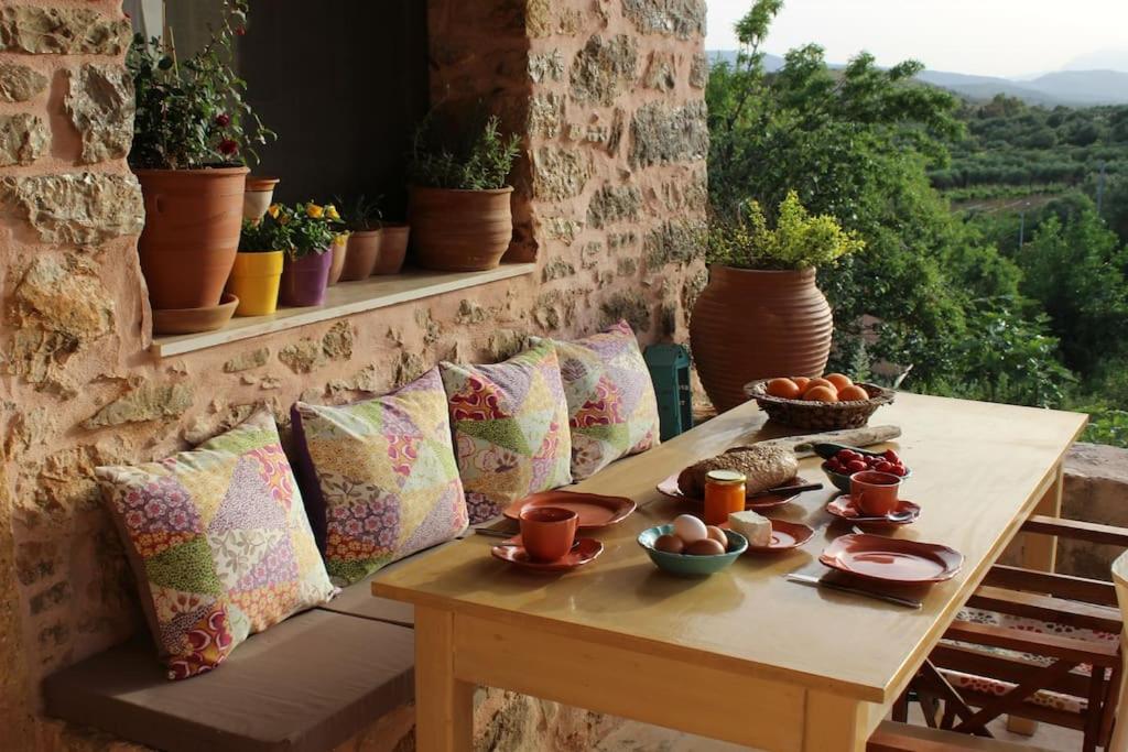 un tavolo in legno con ciotole di cibo sul balcone di House in Organic Orgon farm a Apóstoloi
