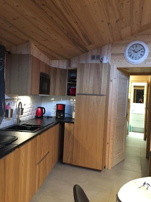 a kitchen with wooden cabinets and a clock on the ceiling at Le petit Saint Bernard in Sainte-Foy-Tarentaise