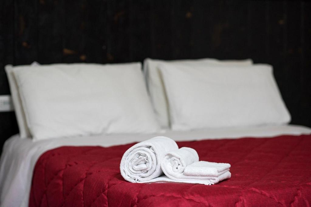 uma cama com toalhas brancas e almofadas em Bed & Breakfast Ellenica em Rionero in Vulture