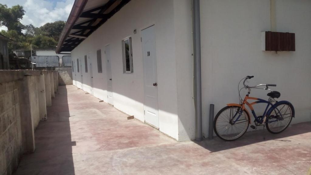 een fiets geparkeerd naast een gebouw met een muur bij Hofste appartementen in Paramaribo