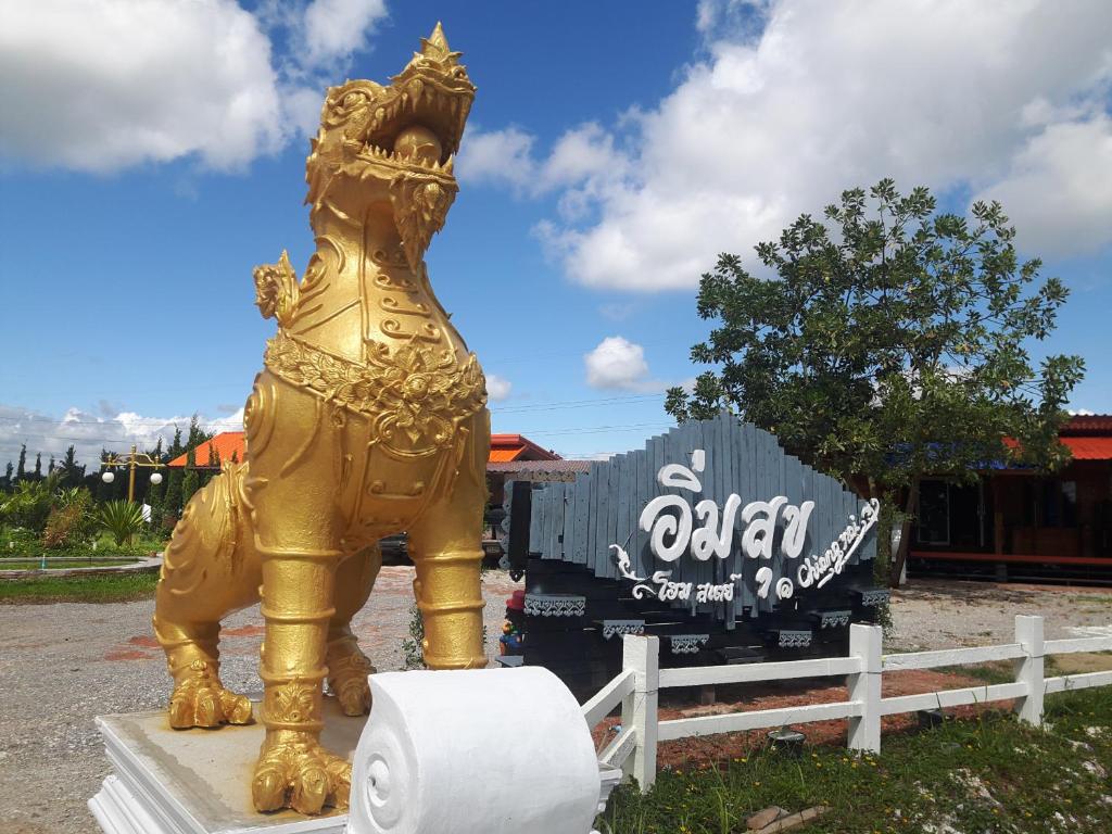 a gold elephant statue in front of a truck at Imsuk Homestay at Chiang Rai in Chiang Rai