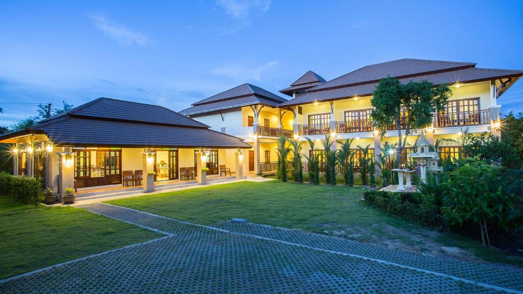 una casa grande con césped delante en Oh Amphawa Boutique Resort, en Amphawa