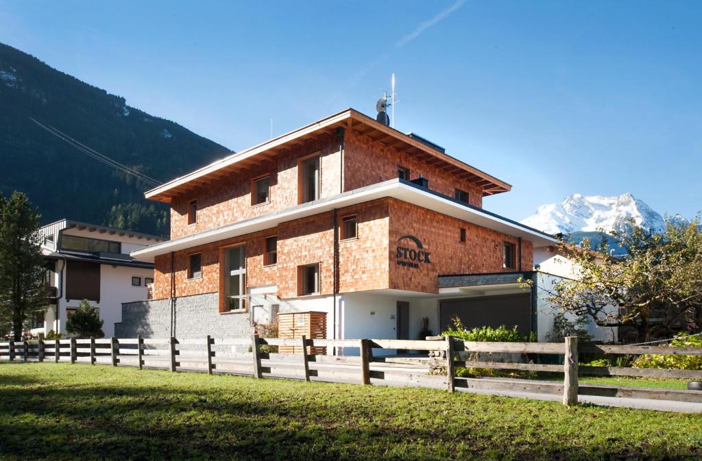 a house in the mountains with a fence at Stock Apartments in Mayrhofen