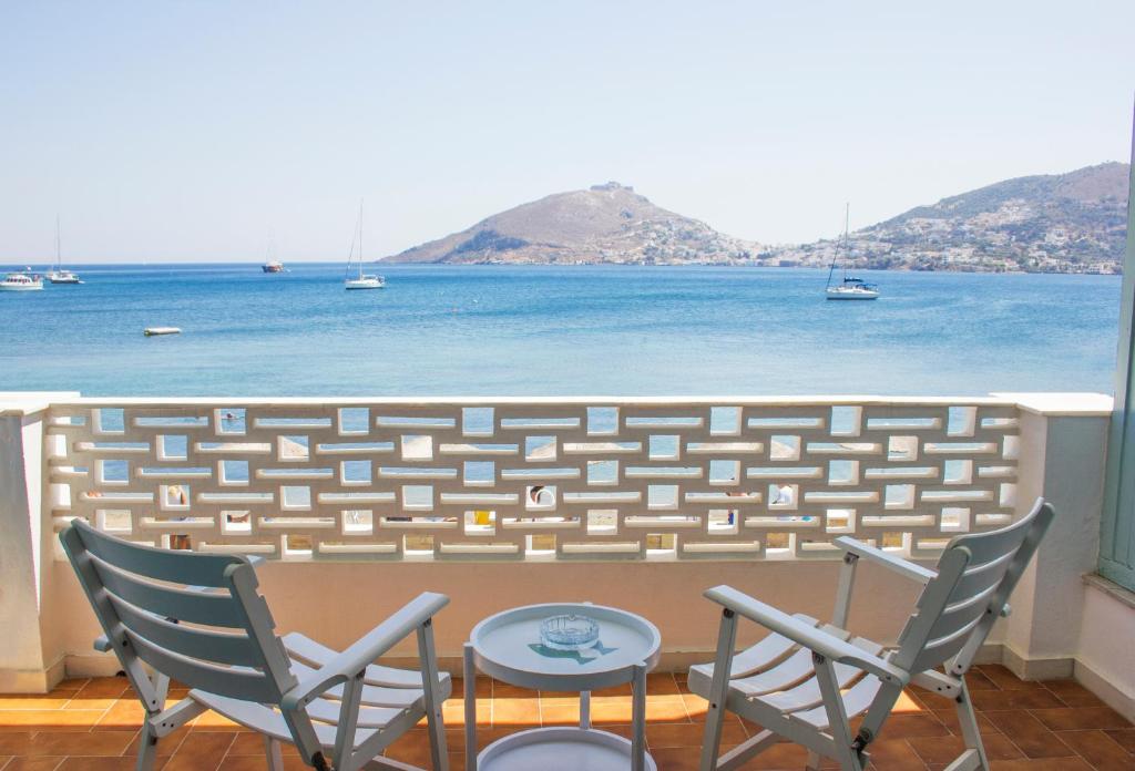 Un balcón con sillas y vistas al océano. en Alea Mare Hotel en Alinda