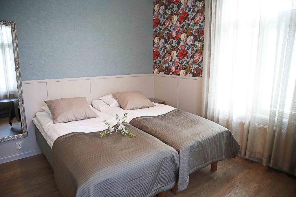 a bedroom with a large bed with flowers on it at Savonlinnan Kansanopisto - Wanha Pappila in Savonlinna