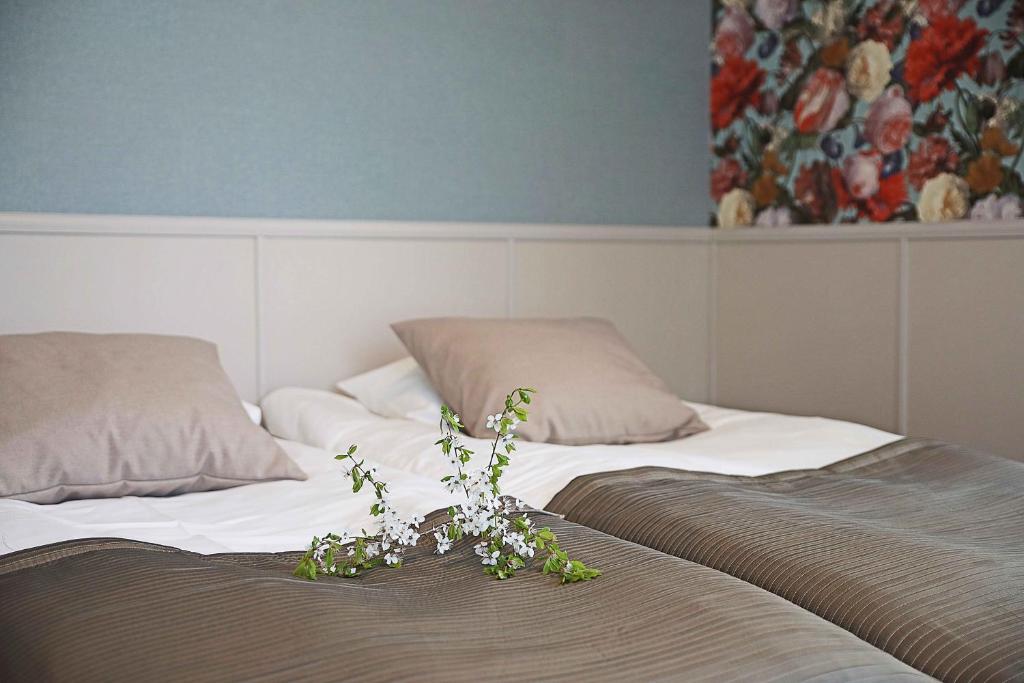 1 dormitorio con 2 camas con flores en Savonlinnan Kansanopisto - Wanha Pappila en Savonlinna