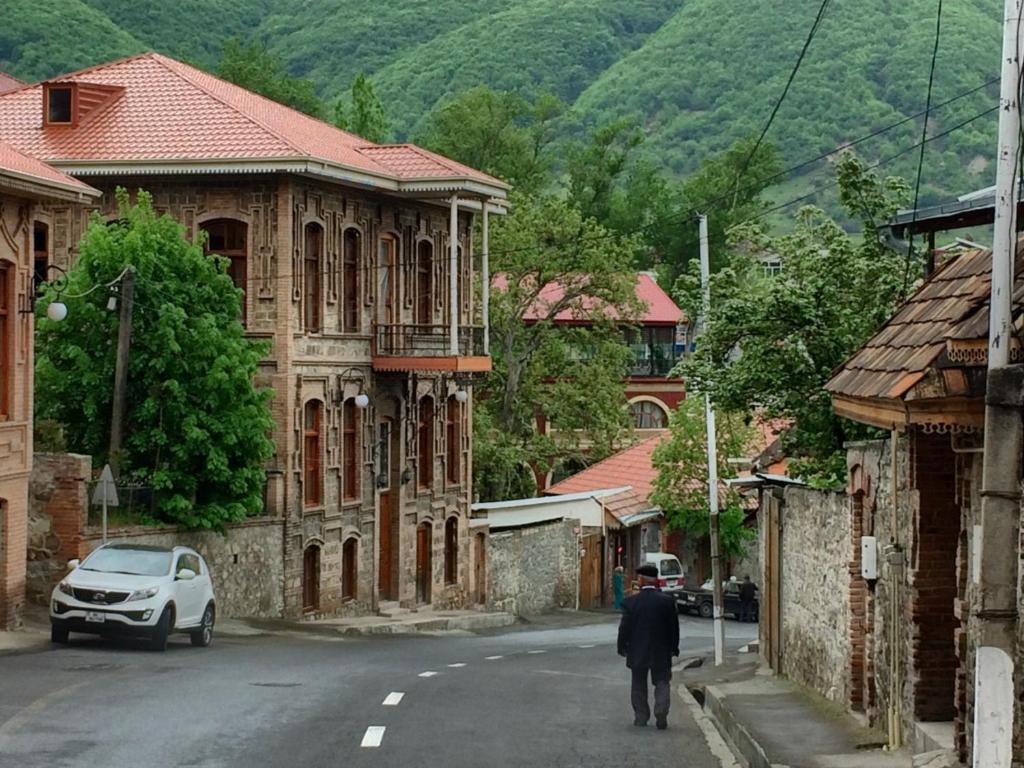 Ein Mann, der in einer Stadt auf einer Straße läuft in der Unterkunft Ansera Residence Sheki in Şəki